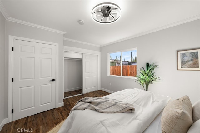 bedroom with dark wood-style floors, a closet, crown molding, and baseboards