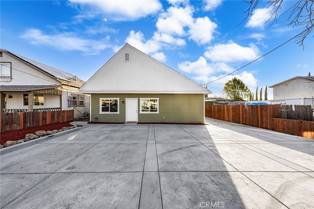 rear view of property featuring fence and a patio