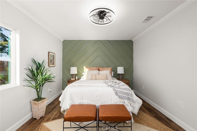 bedroom featuring crown molding, baseboards, visible vents, and wood finished floors