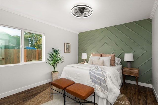 bedroom with baseboards, ornamental molding, and wood finished floors