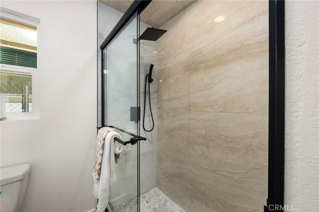 bathroom featuring a shower stall and toilet