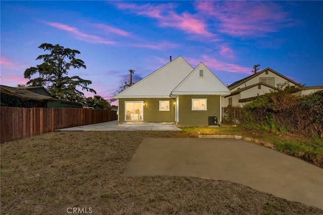 back of house featuring a patio, a fenced backyard, central AC, and a yard