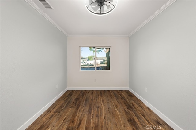 empty room with ornamental molding, visible vents, dark wood-type flooring, and baseboards