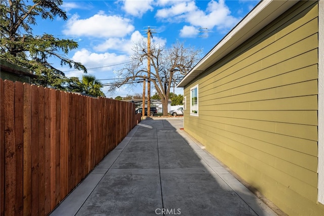 view of side of property featuring a patio area and fence