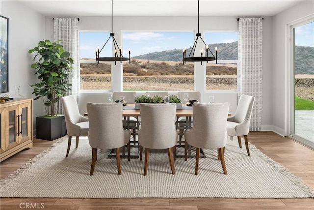 dining space featuring an inviting chandelier, wood-type flooring, and a mountain view