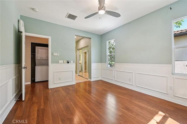 33 Perennial, Irvine, CA 92603 - unfurnished bedroom with stacked washer / drying machine, wood finished floors, multiple windows, wainscoting, and a decorative wall