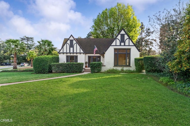 tudor house with a front lawn and stucco siding