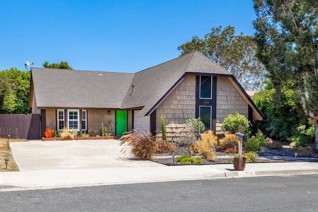 view of front of property with a shingled roof and fence