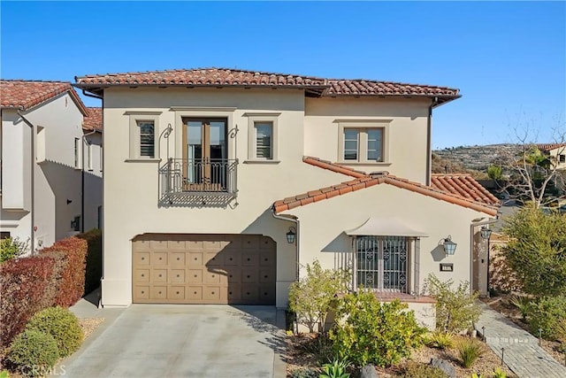 mediterranean / spanish-style house with a tile roof, driveway, and stucco siding