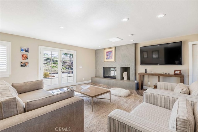 living room with recessed lighting, a large fireplace, and baseboards