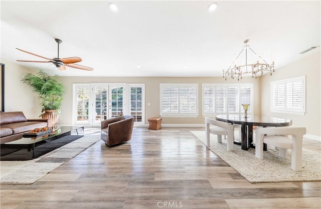 living room with baseboards, light wood-type flooring, visible vents, and recessed lighting