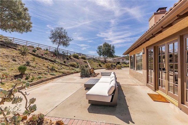 view of patio featuring french doors and fence