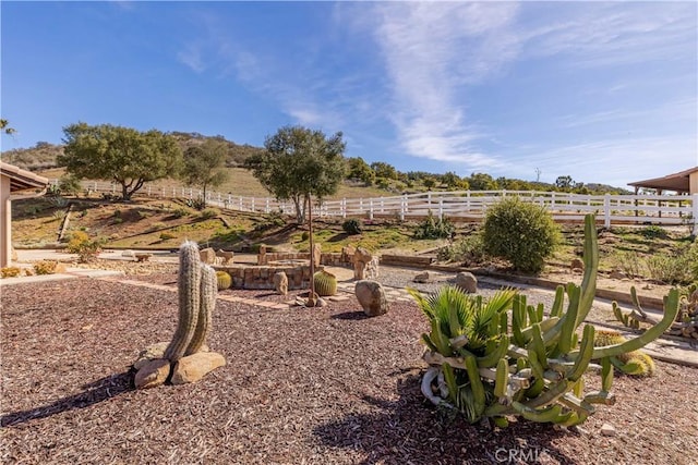 view of yard featuring fence and a rural view