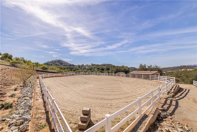 view of yard featuring an enclosed area, a rural view, and a mountain view