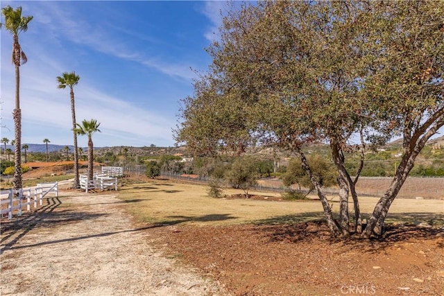 view of yard featuring fence and a rural view