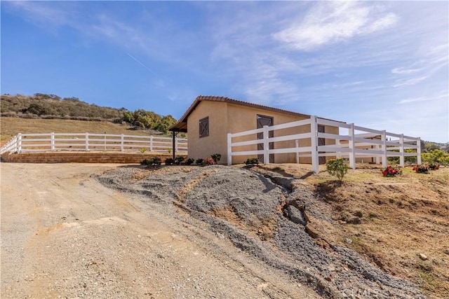 view of outbuilding with a rural view and fence