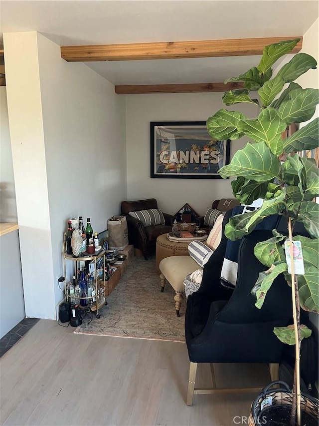 living area with beamed ceiling and wood finished floors