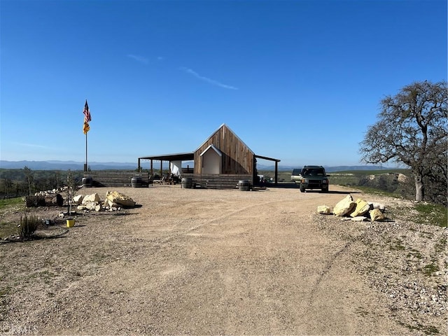 view of yard featuring driveway, a rural view, and a mountain view