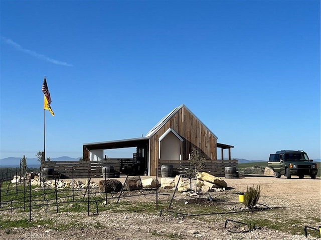 surrounding community featuring an exterior structure, a mountain view, and an outdoor structure