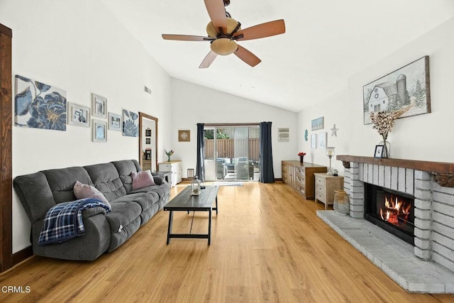 living room with a brick fireplace, high vaulted ceiling, light hardwood / wood-style flooring, and ceiling fan