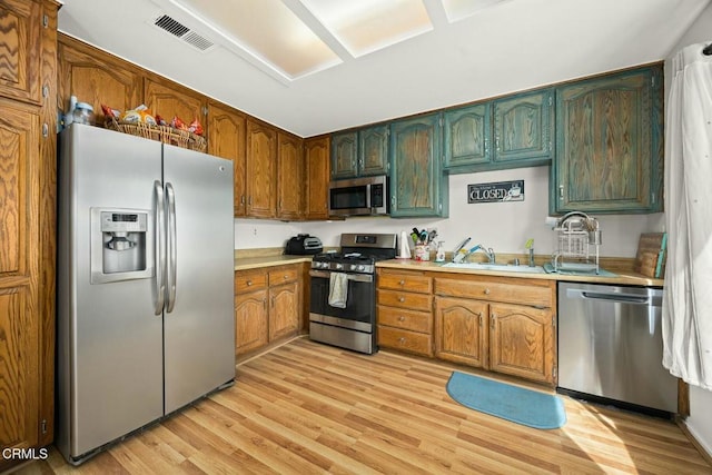 16606 Shinedale Dr, Canyon Country, CA 91387 - kitchen with stainless steel appliances, a sink, light wood-type flooring, and light countertops