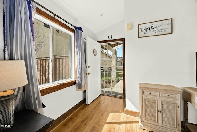 16606 Shinedale Dr, Canyon Country, CA 91387 - doorway with light wood-style flooring, vaulted ceiling, and baseboards