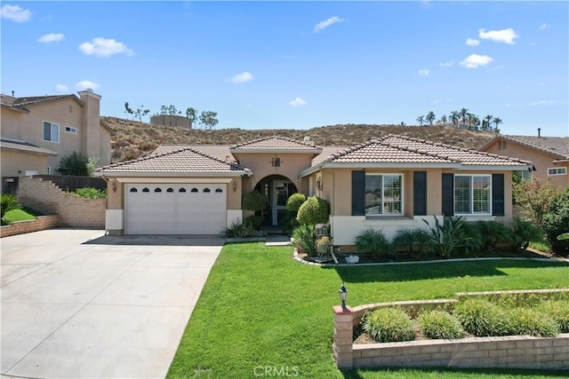 mediterranean / spanish home with a front lawn and a garage