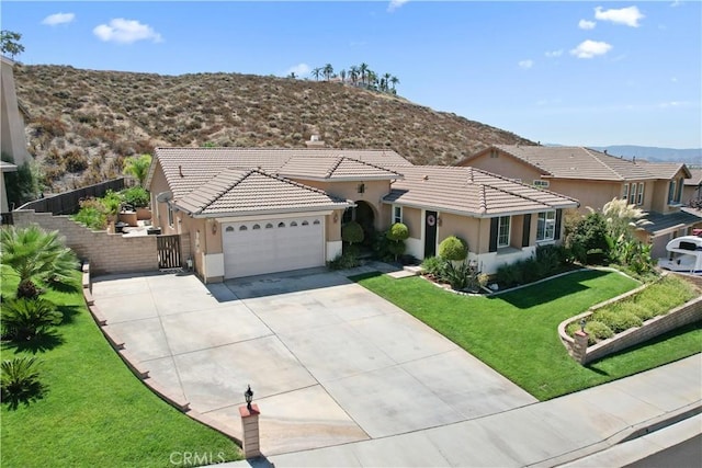 view of front of home featuring a front lawn, a garage, and a mountain view