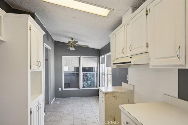 kitchen featuring white cabinetry, ceiling fan, light tile patterned floors, and a textured ceiling