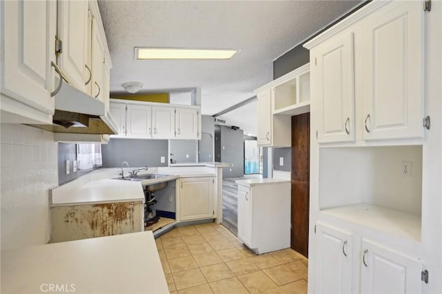 kitchen with white cabinets, light tile patterned floors, sink, and kitchen peninsula