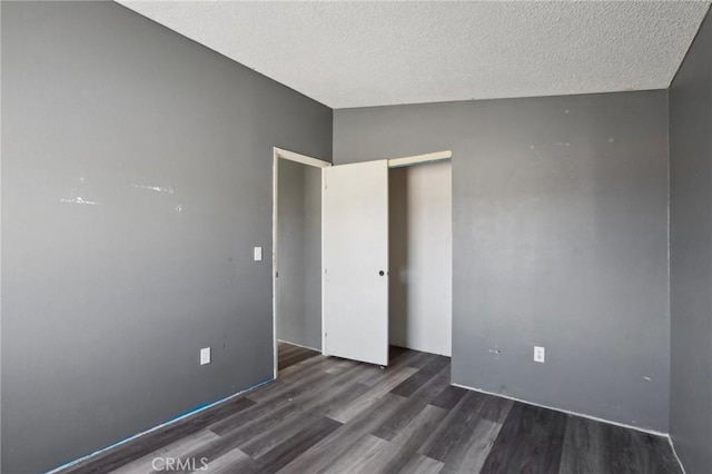 spare room with dark wood-type flooring and a textured ceiling