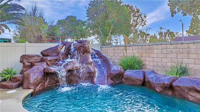 view of swimming pool featuring a swimming pool and fence