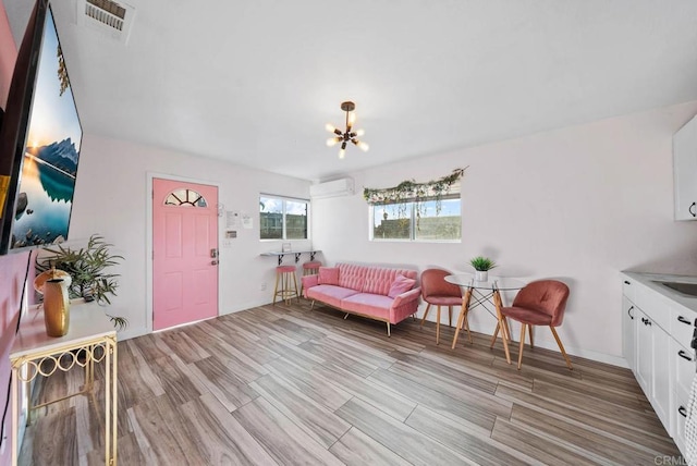 interior space with sink, light hardwood / wood-style flooring, a wall unit AC, and a chandelier