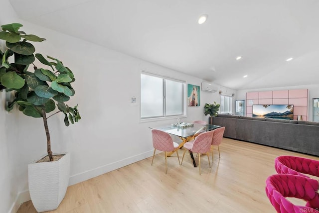 dining area featuring light wood-type flooring, a wall unit AC, and lofted ceiling