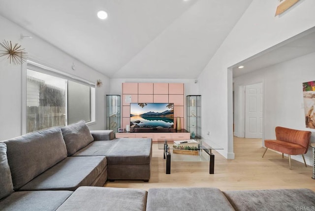 living room with light hardwood / wood-style floors and vaulted ceiling