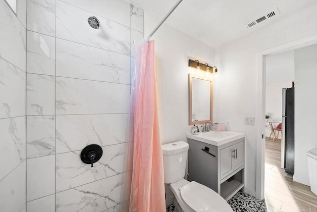 bathroom featuring toilet, vanity, and curtained shower