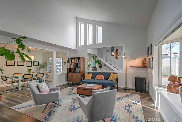 living room with dark hardwood / wood-style flooring and high vaulted ceiling