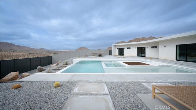 8750 Desert Shadows, Joshua Tree, CA 92252 - view of pool featuring a fenced backyard, a patio area, a mountain view, and a pool with connected hot tub