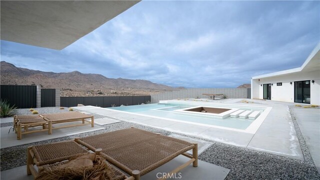 8750 Desert Shadows, Joshua Tree, CA 92252 - fenced backyard featuring a mountain view, a patio, and an in-ground hot tub