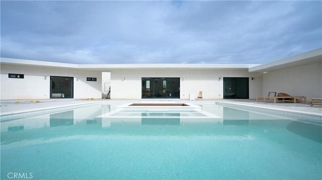 back of house with an outdoor pool, stucco siding, and a patio