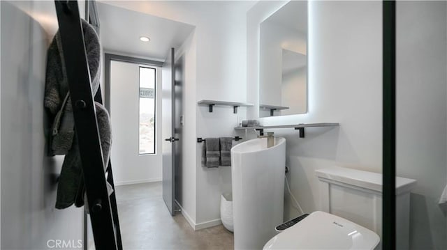 8750 Desert Shadows, Joshua Tree, CA 92252 - bathroom featuring concrete flooring, baseboards, toilet, and recessed lighting