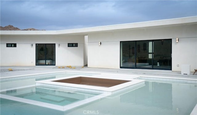 view of pool with a pool with connected hot tub