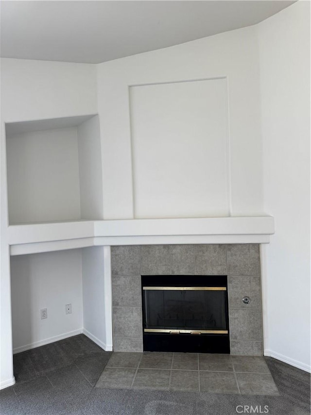 details with a tile fireplace and carpet floors