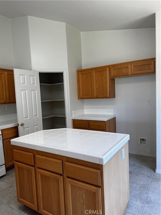 kitchen featuring tile counters, a kitchen island, and light tile patterned floors