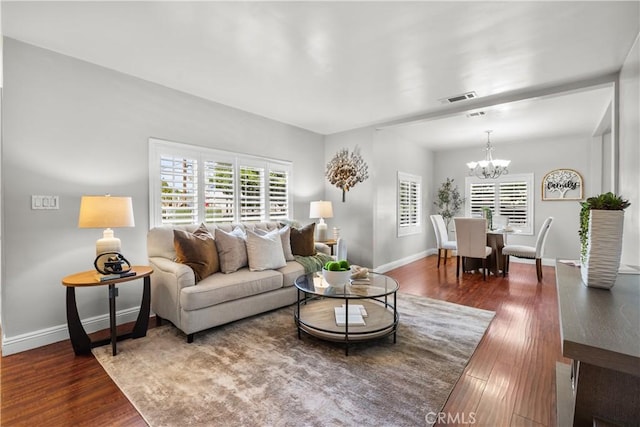 living room featuring a chandelier and dark hardwood / wood-style flooring