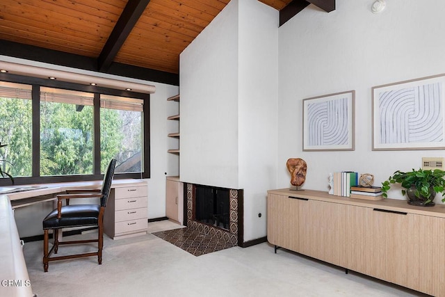 home office with a tiled fireplace, wooden ceiling, vaulted ceiling with beams, and light colored carpet