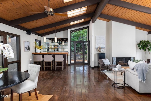 living room with beamed ceiling, dark hardwood / wood-style floors, ceiling fan, and wood ceiling