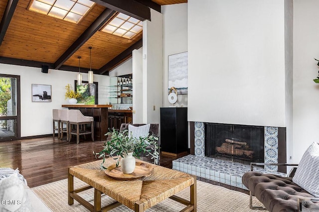 living room featuring a fireplace, wood ceiling, indoor bar, beam ceiling, and hardwood / wood-style floors