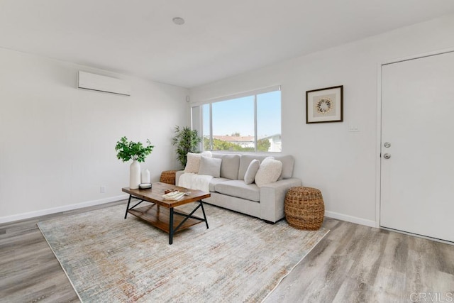 living room featuring a wall mounted AC and light hardwood / wood-style flooring