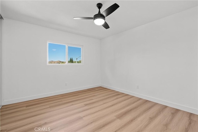 empty room with ceiling fan and light hardwood / wood-style flooring